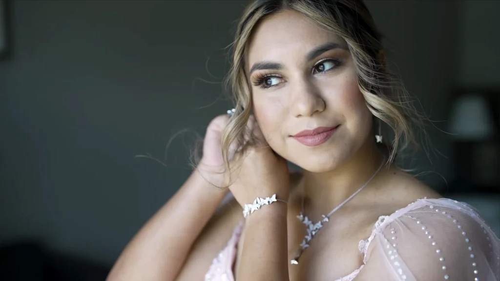 Young woman in a pink quinceañera dress preparing for her celebration