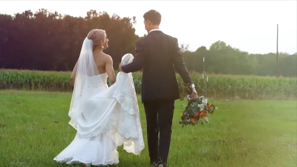 Bride and groom walking through a field at sunset during their wedding at The Farm at Ridgeway in South Carolina