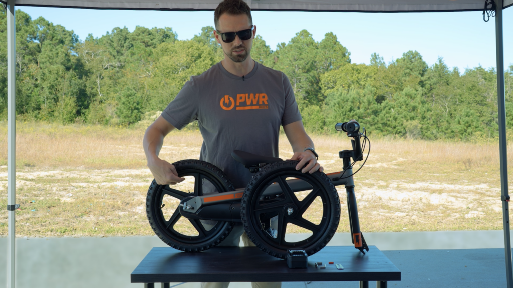 Person assembling a Superbolt electric balance bike during an unboxing and setup tutorial