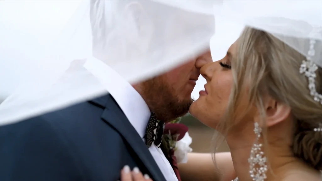 Bride and groom sharing a kiss beneath a wedding veil at Twelve Oaks Estate in South Carolina